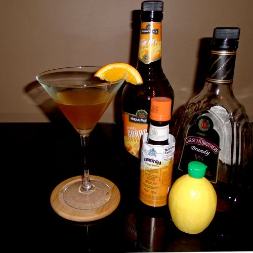 Sidecar, garnished with an orange wedge and presen