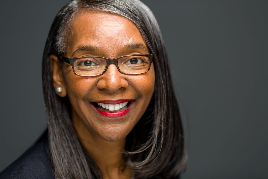 Corporate headshot on a dark grey background
