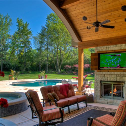Covered patio with stone fireplace, bar area with 