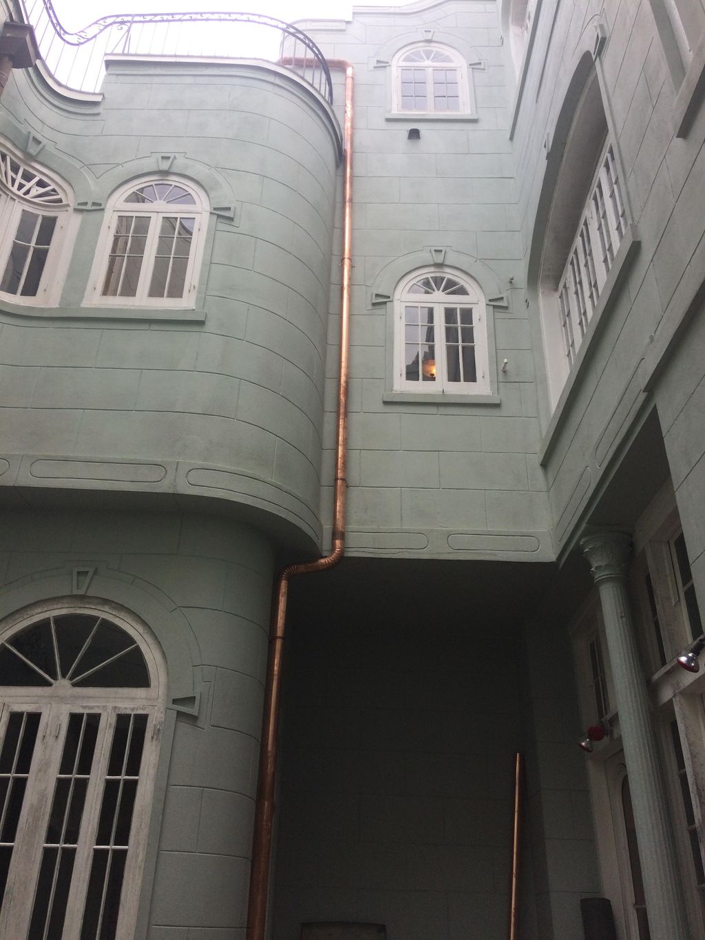 Custom copper downspout in a courtyard of the Fren