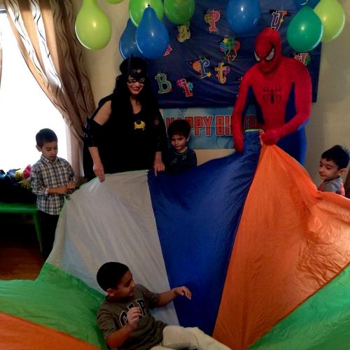 Bat Girl and Spider man playing games with the kid