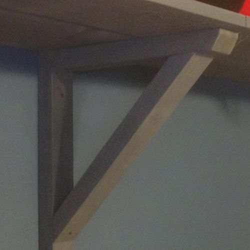 Bracket to support open shelves in a bedroom.