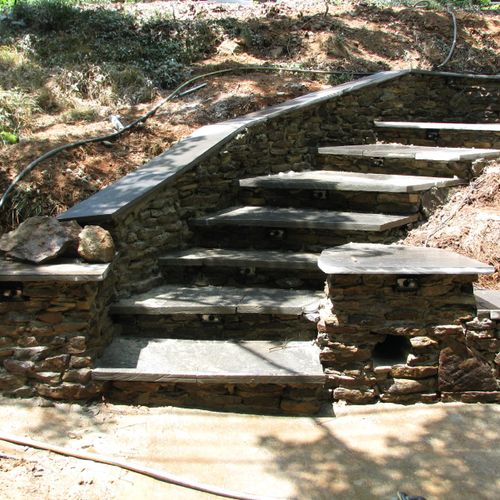 View of curved stone stairway up to home