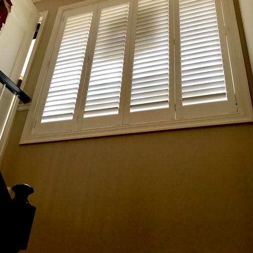 Shutters in large window over stairs