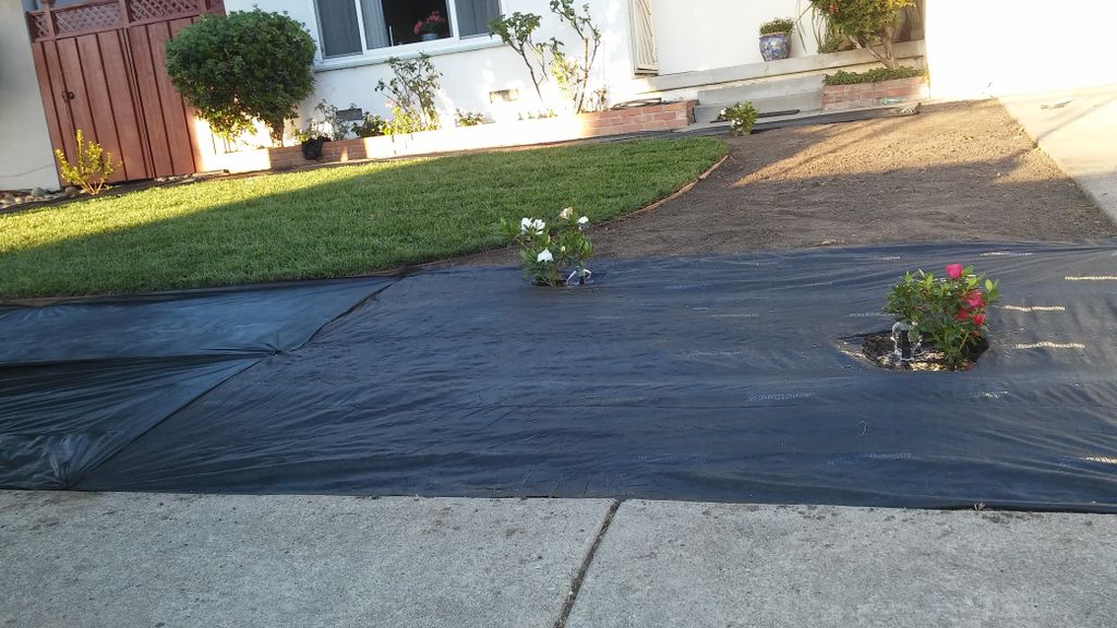 Laying down weed barrier prior to rock installatio