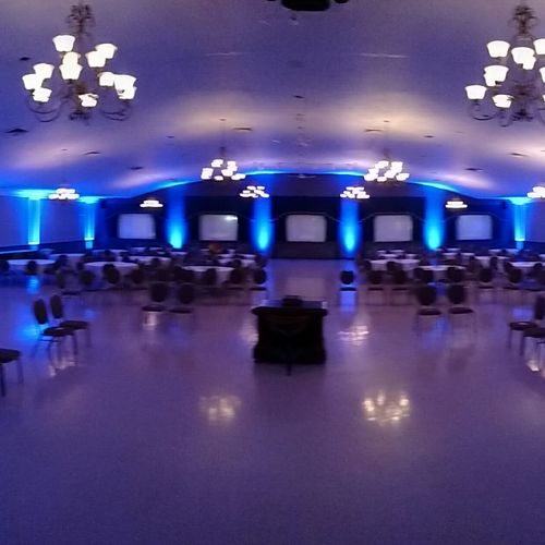 A ballroom uplit in blue the evening before an eve