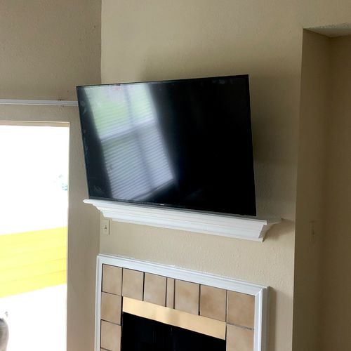 Tv mounted above fireplace. 