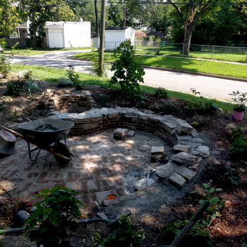 Custom sunken brick patio with stone sitting wall 