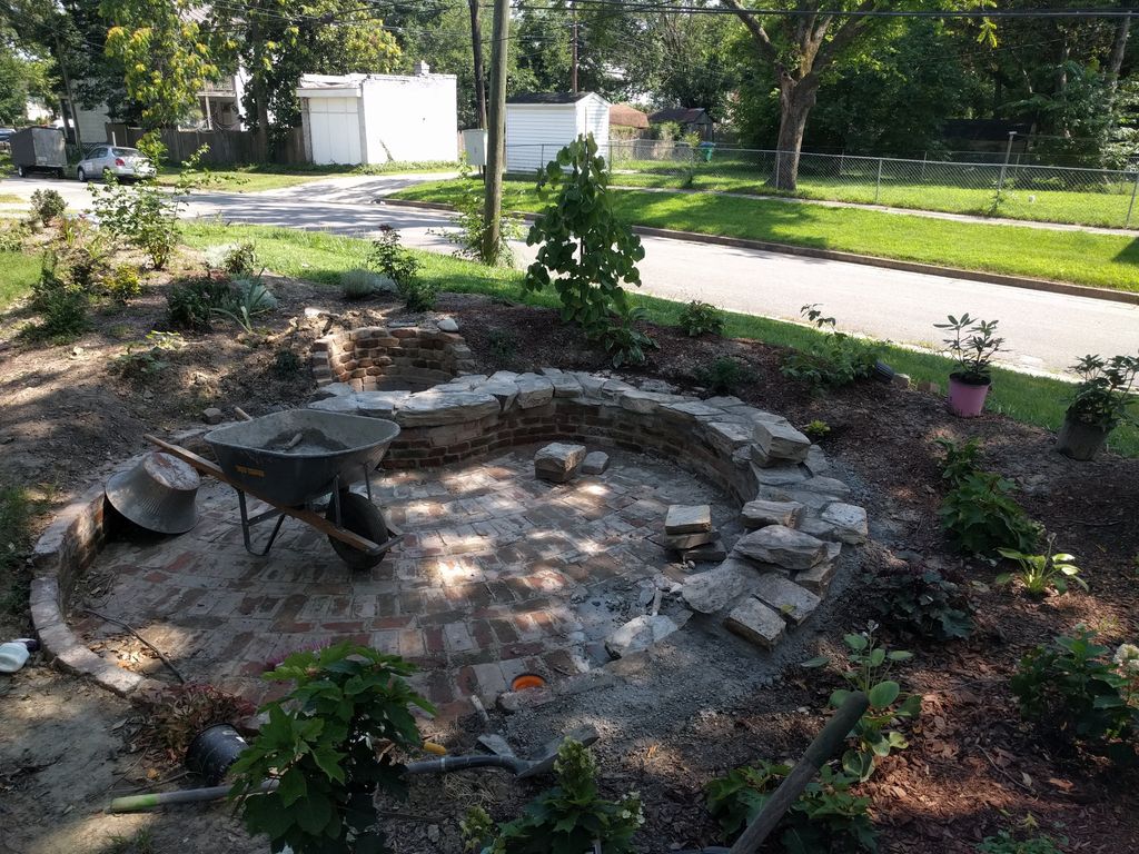 Custom sunken brick patio with stone sitting wall 