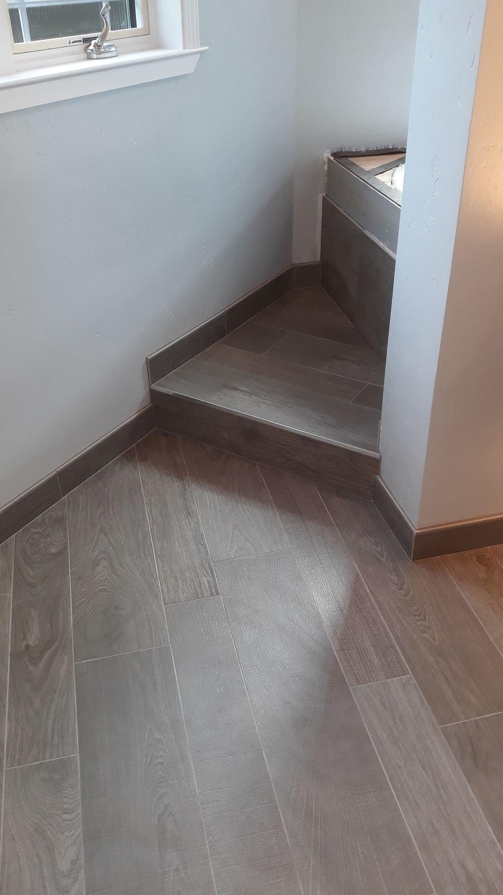 Hardwood floor lookalike porcelain tile with step