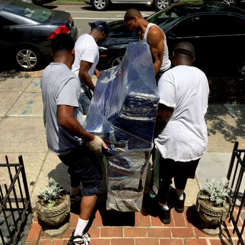 Guys carefully moving a piano