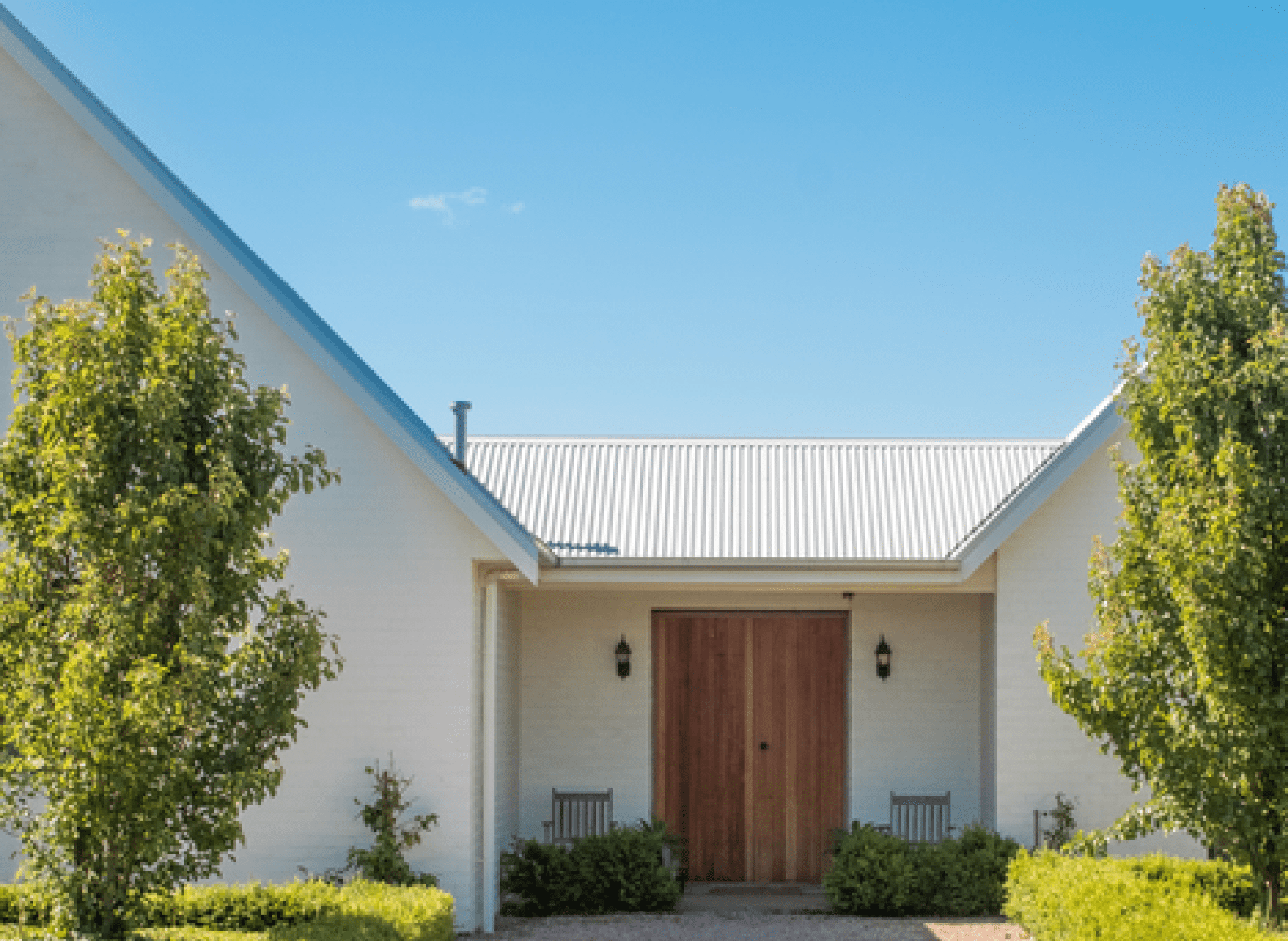 light colored metal roof on house with wooden front door