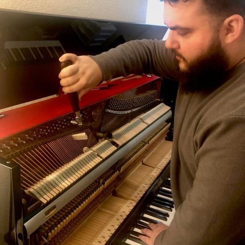 Alex tuning an upright piano