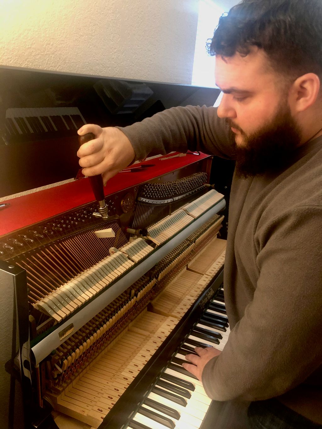 Alex tuning an upright piano