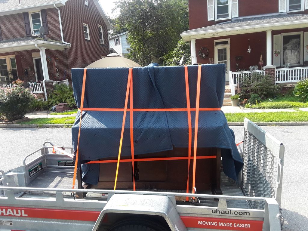 large upright piano- covered and strapped 