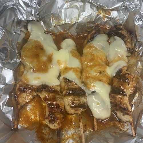 Chicken skewers topped with provolone cheese 