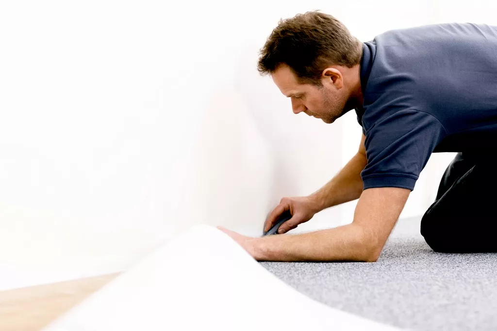 man installing vinyl flooring