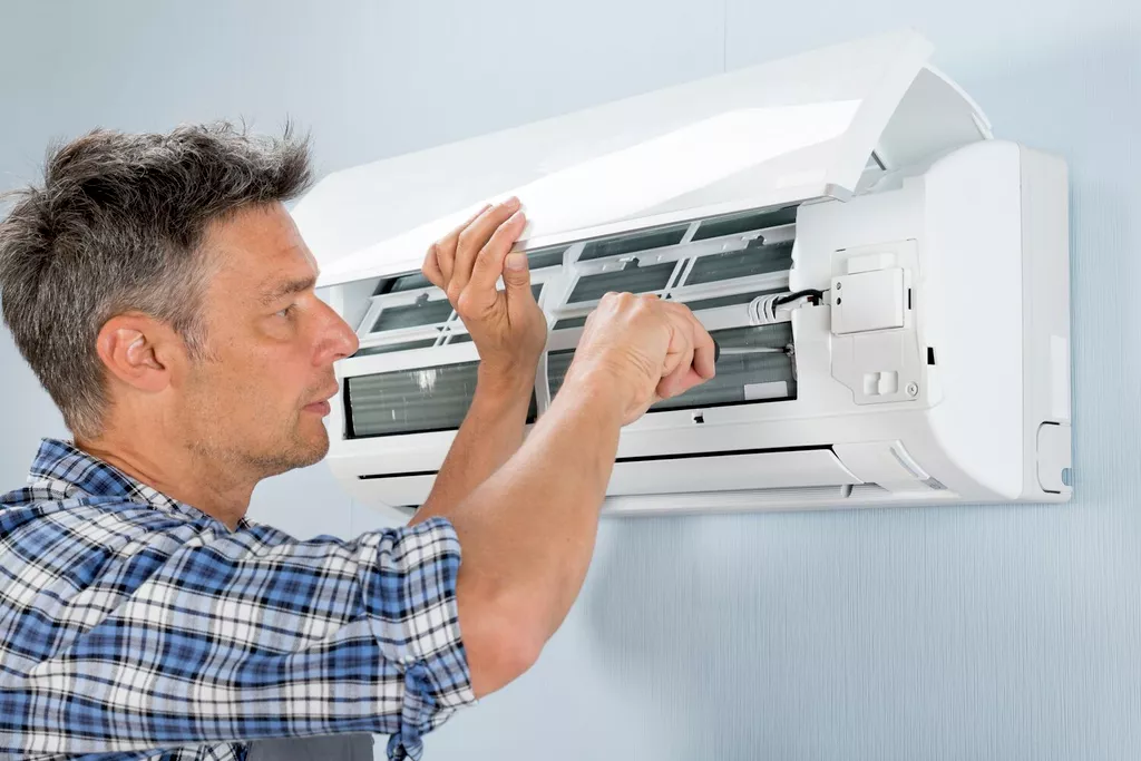 man fixing smell coming from HVAC