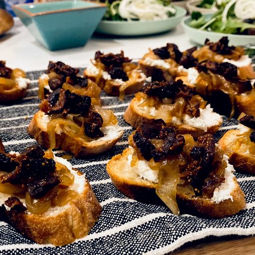 Crostini with red wine soaked figs caramelized onions and chèvre .