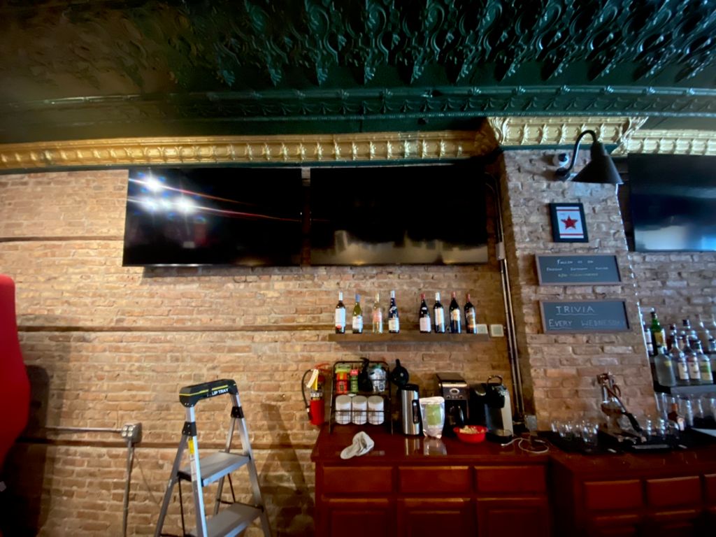 TVs mounted on brick wall at Moran’s Pub