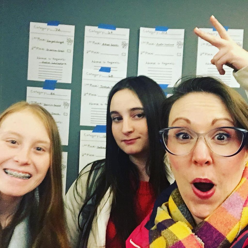 Jenni with students and the posted list of winners