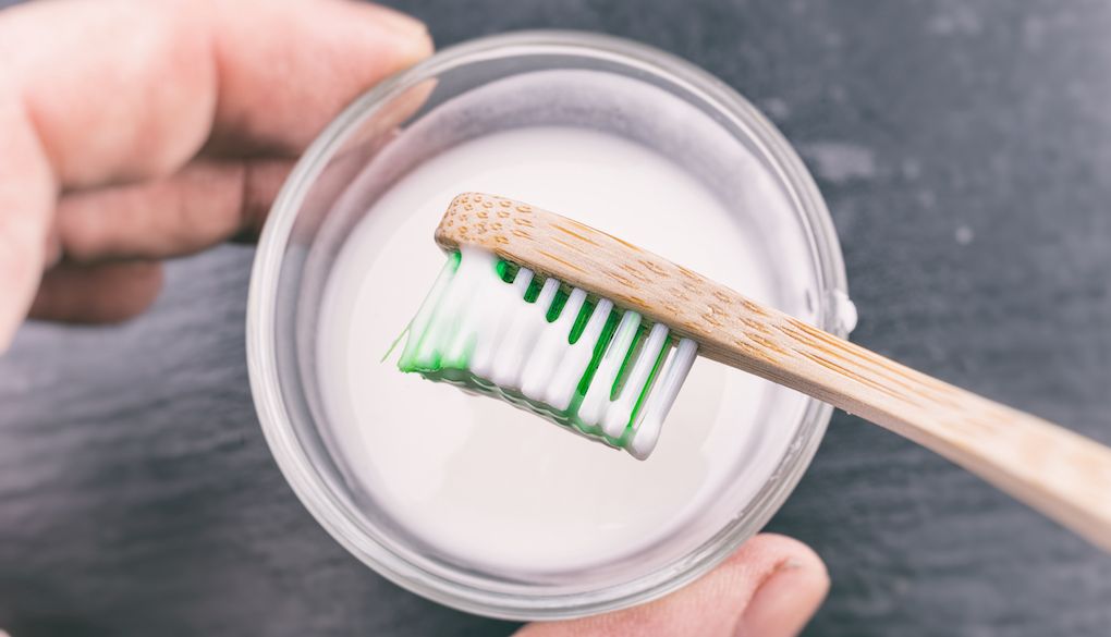 baking soda paste on toothbrush to clean showerhead