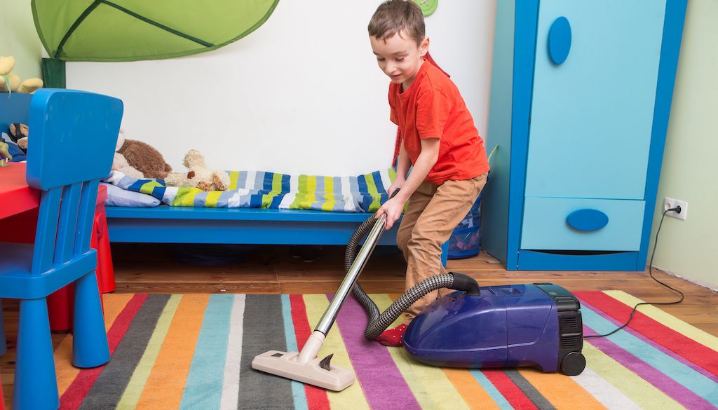child vacuuming his bedroom