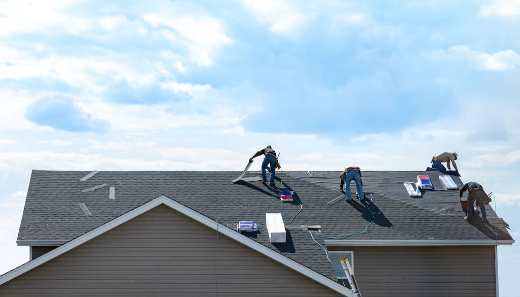 roofers on top of house