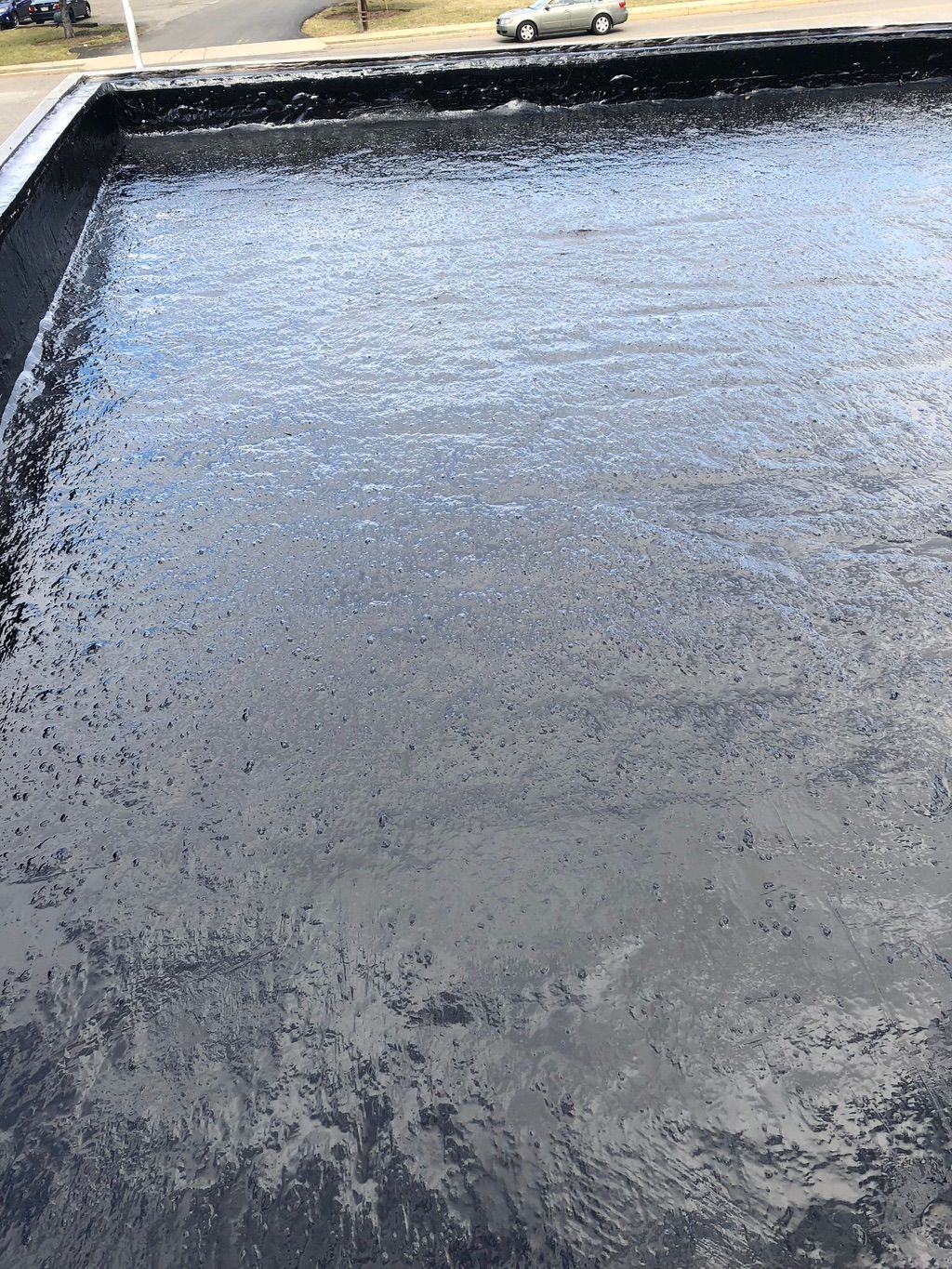 Applied an oil based coating to a hot tar roof.