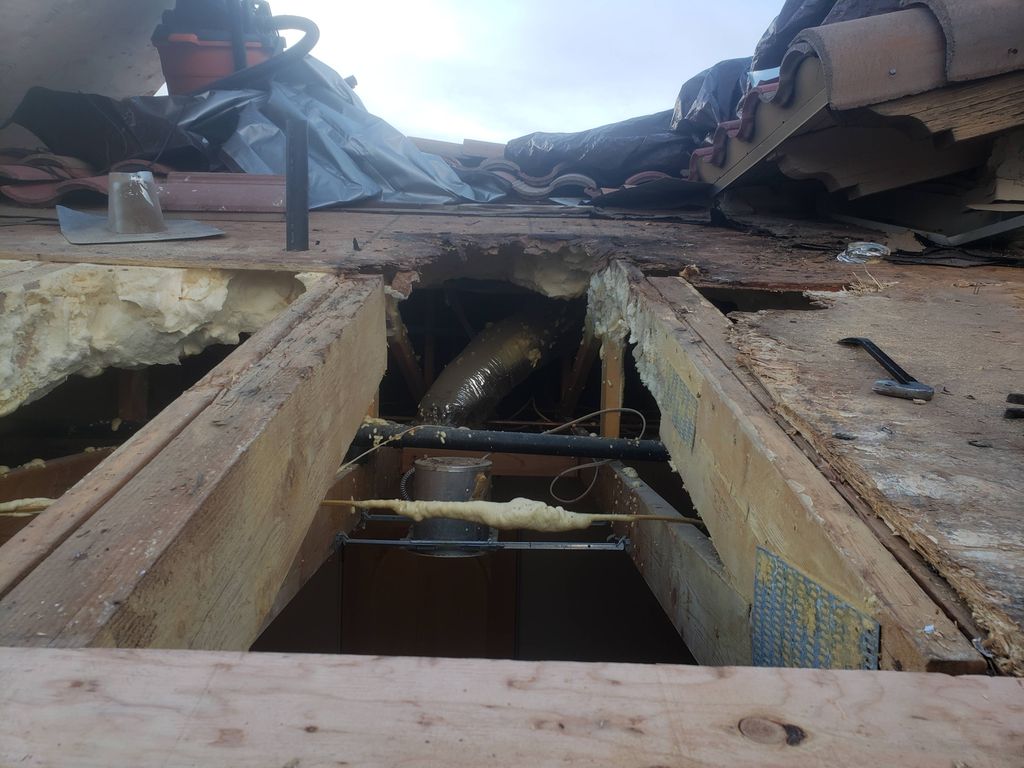 Plywood on a roof after the wood rotted and mold d