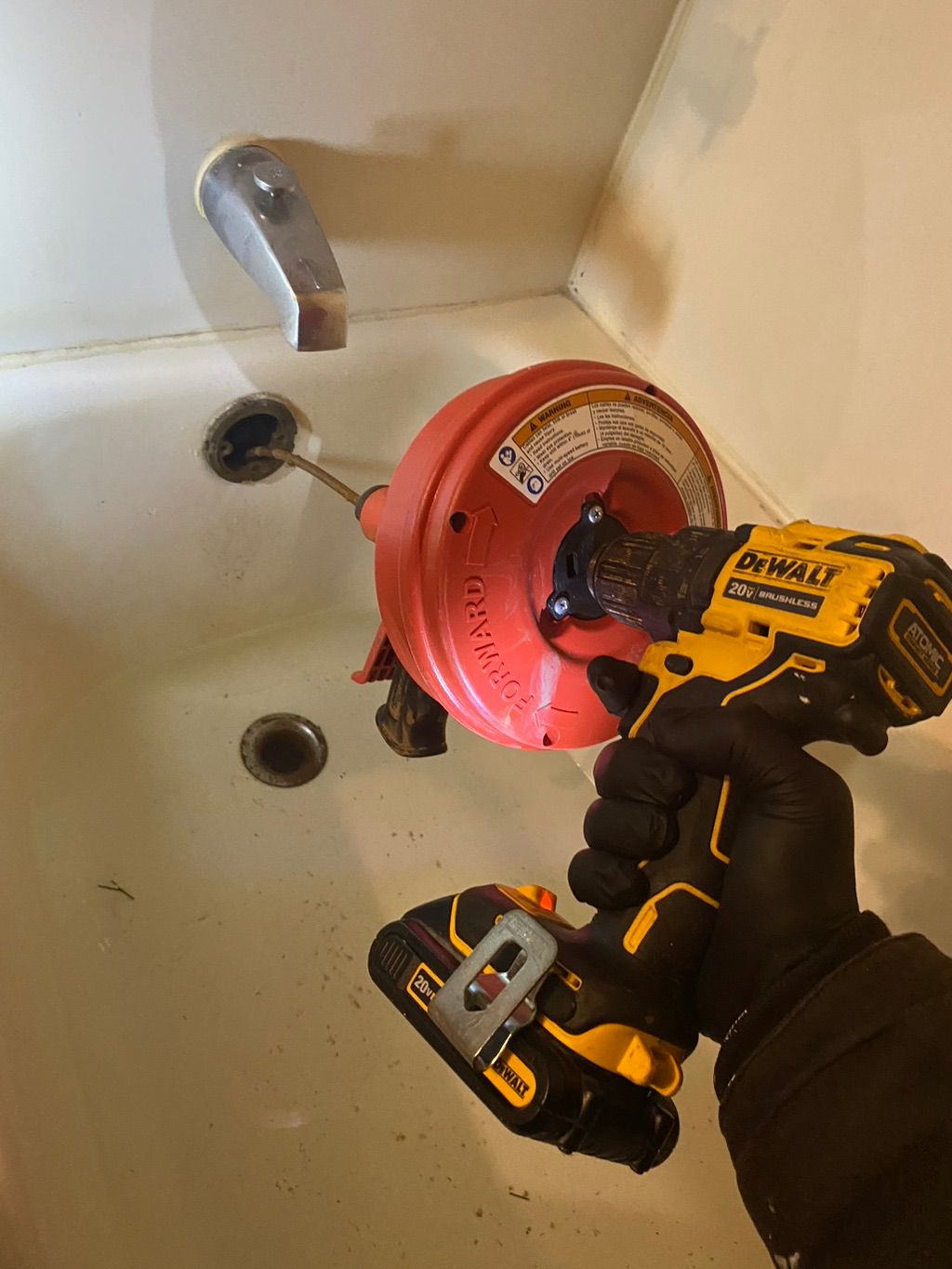 Unclogging tub drain.
