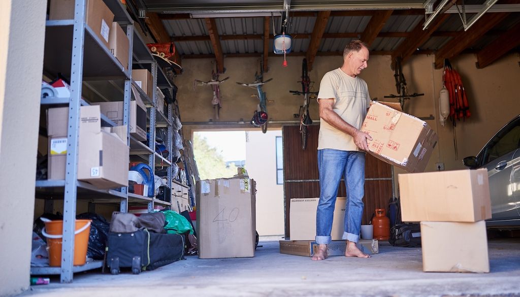 man carrying box in garage