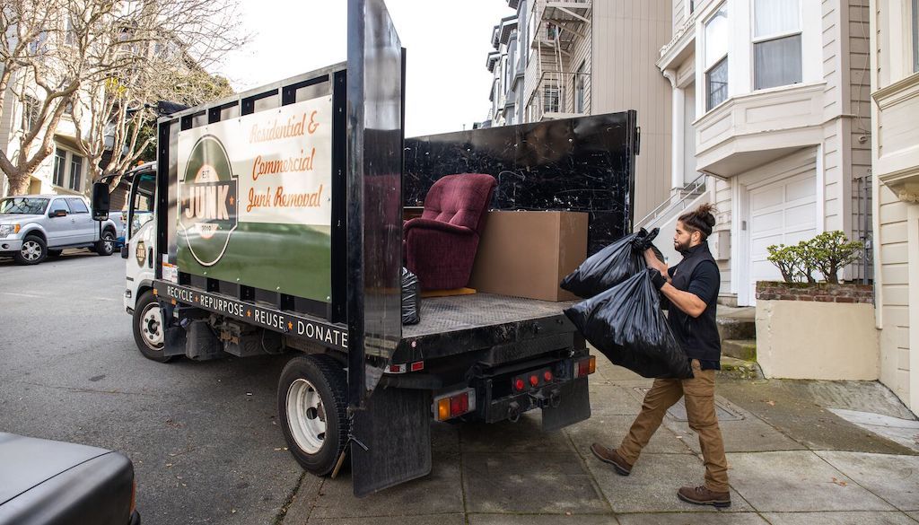 man hauling away junk into truck