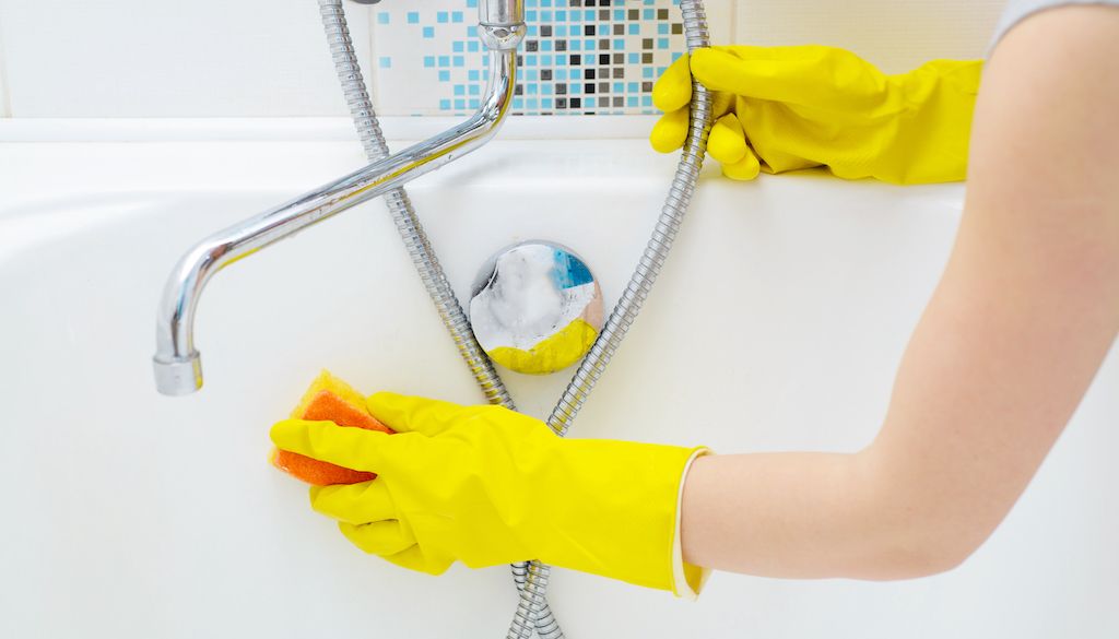 cleaning bathtub with sponge