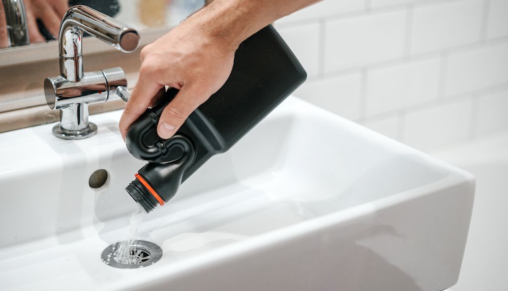 pouring drain cleaner in sink