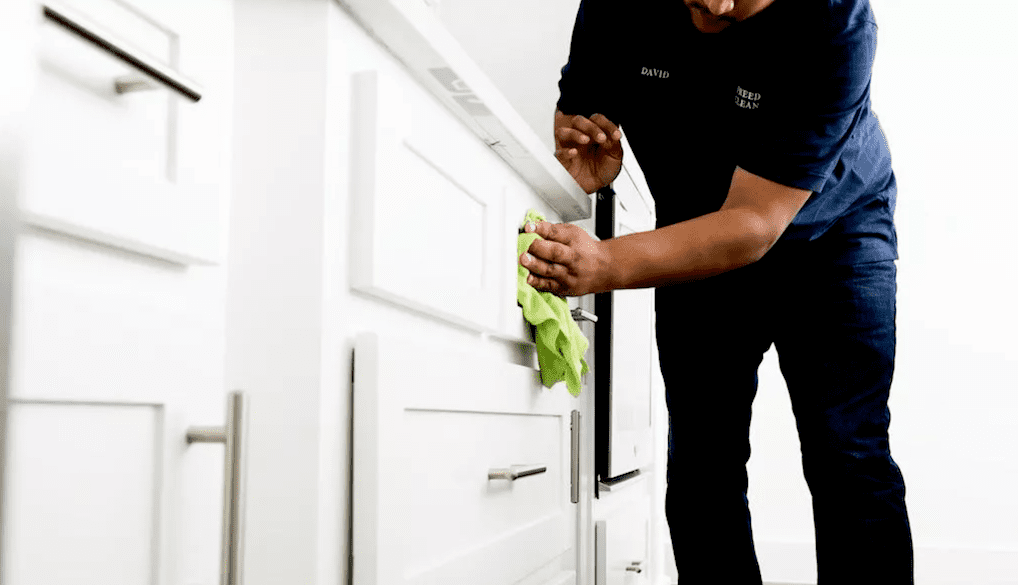 wiping down cabinet handles in kitchen