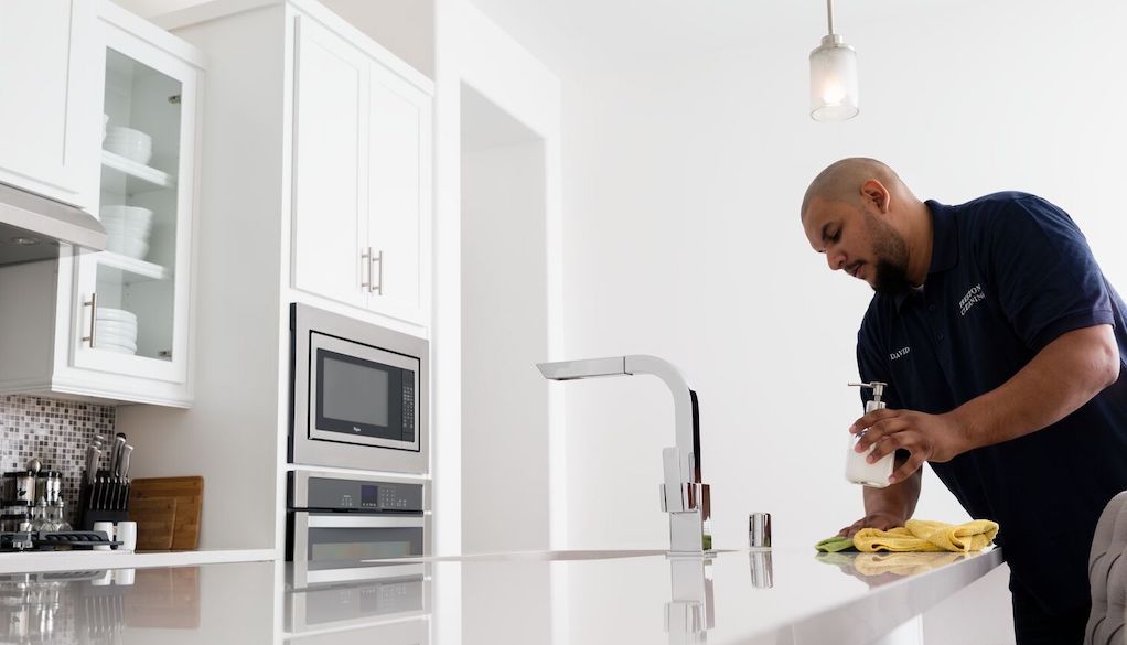 man cleaning kitchen counter with rag