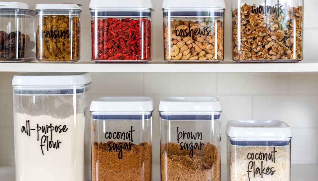 neatly organized and labeled nuts and baking ingredients in containers on shelf