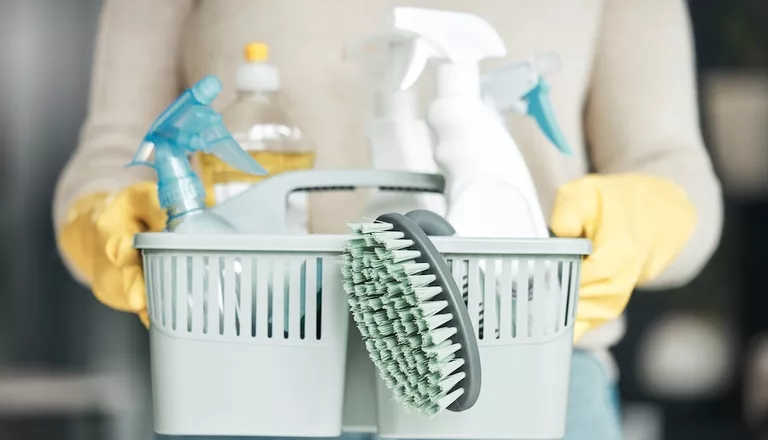 holding basket of cleaning supplies