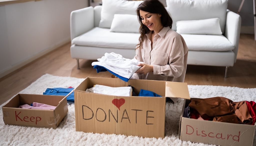 putting items in three contains for donating, keeping and discarding