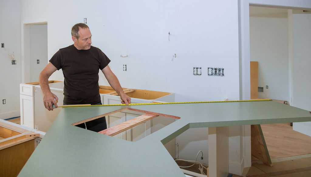 contractor measuring kitchen counter depth and island