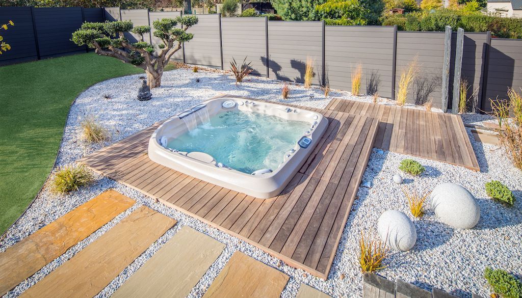 backyard hot tub and spa surrounding by gravel