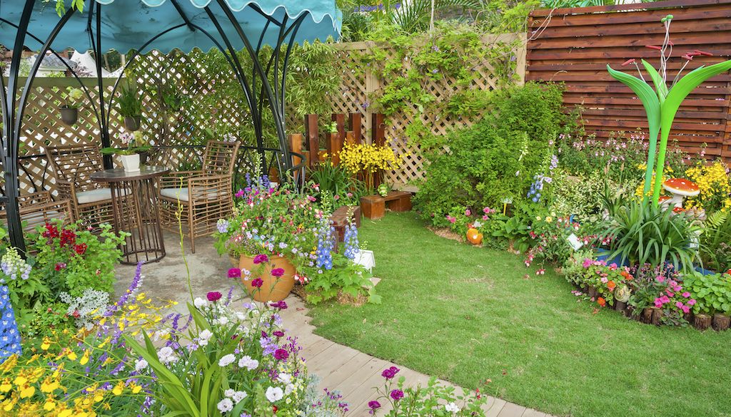 flowers, pathway and small patio in backyard