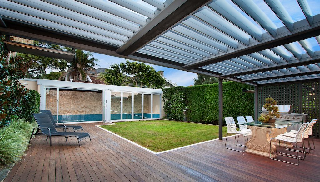 swimming pool fenced off in big backyard courtyard with dining and patio area