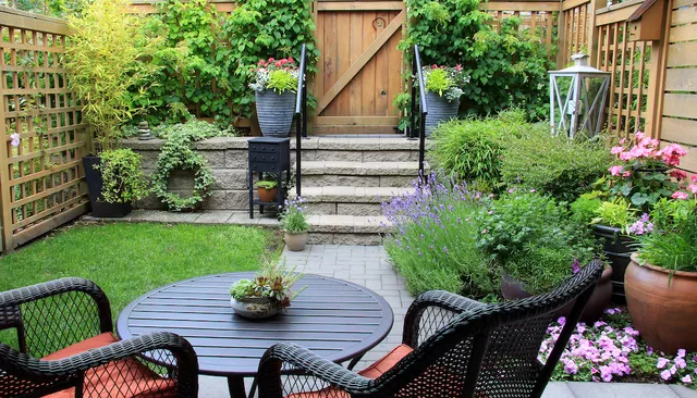 small cozy backyard with high fence and dining area on patio