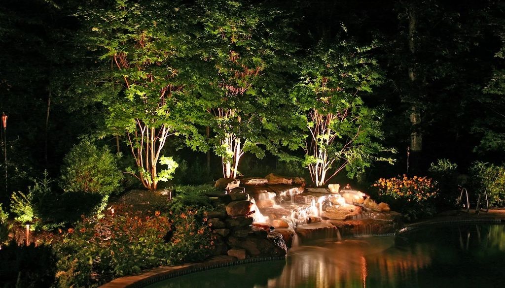 pool waterfall lighting in backyard