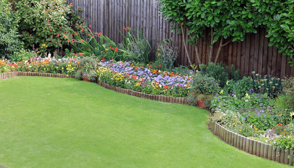 wood edging around flower garden bed in backyard