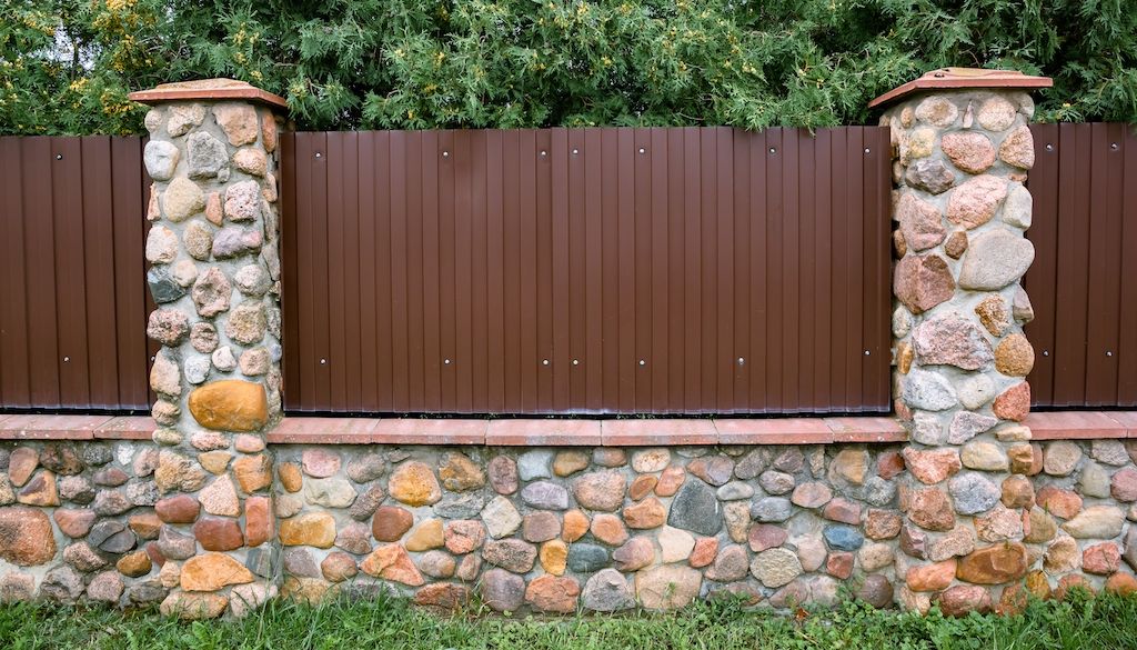 talk metal backyard privacy fence with rocks