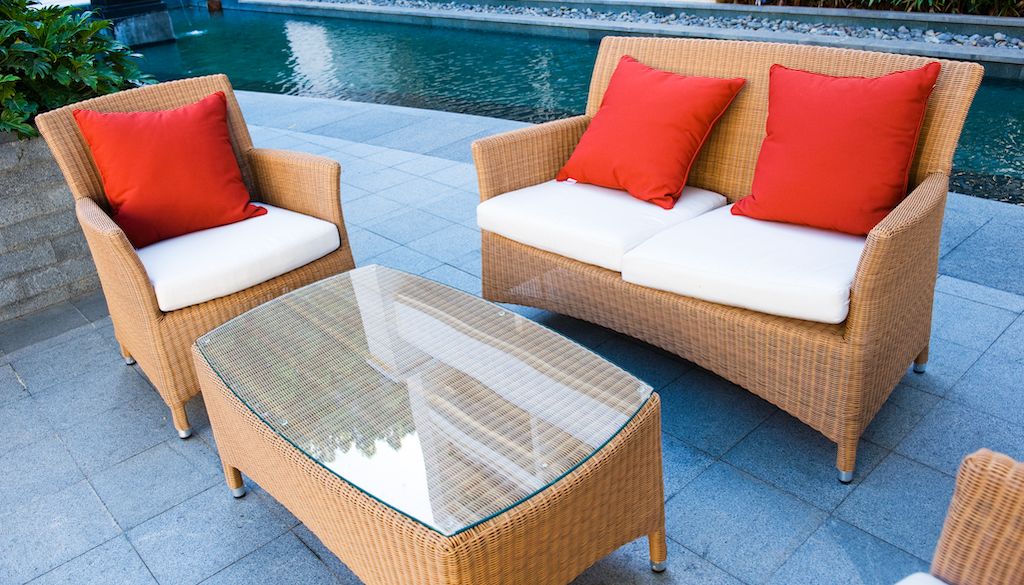 wicker outdoor furniture in seating area near pool