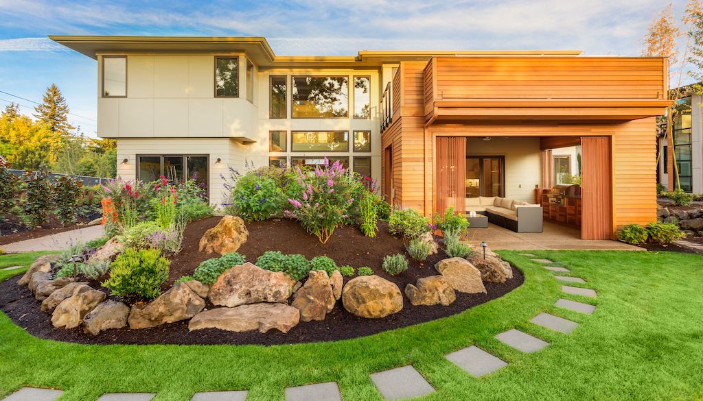 beautiful backyard landscape design with pathway, boulder rocks, garden bed and patio